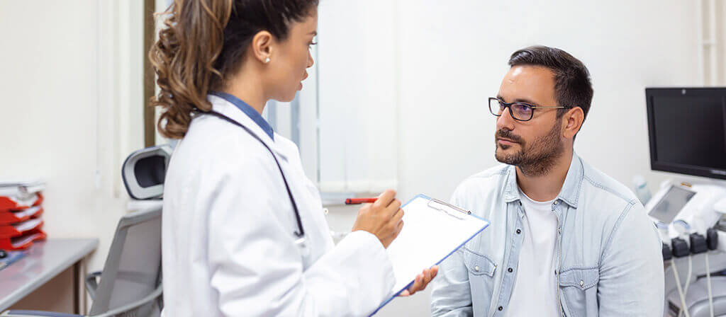 Man sitting while talking to a medical doctor.