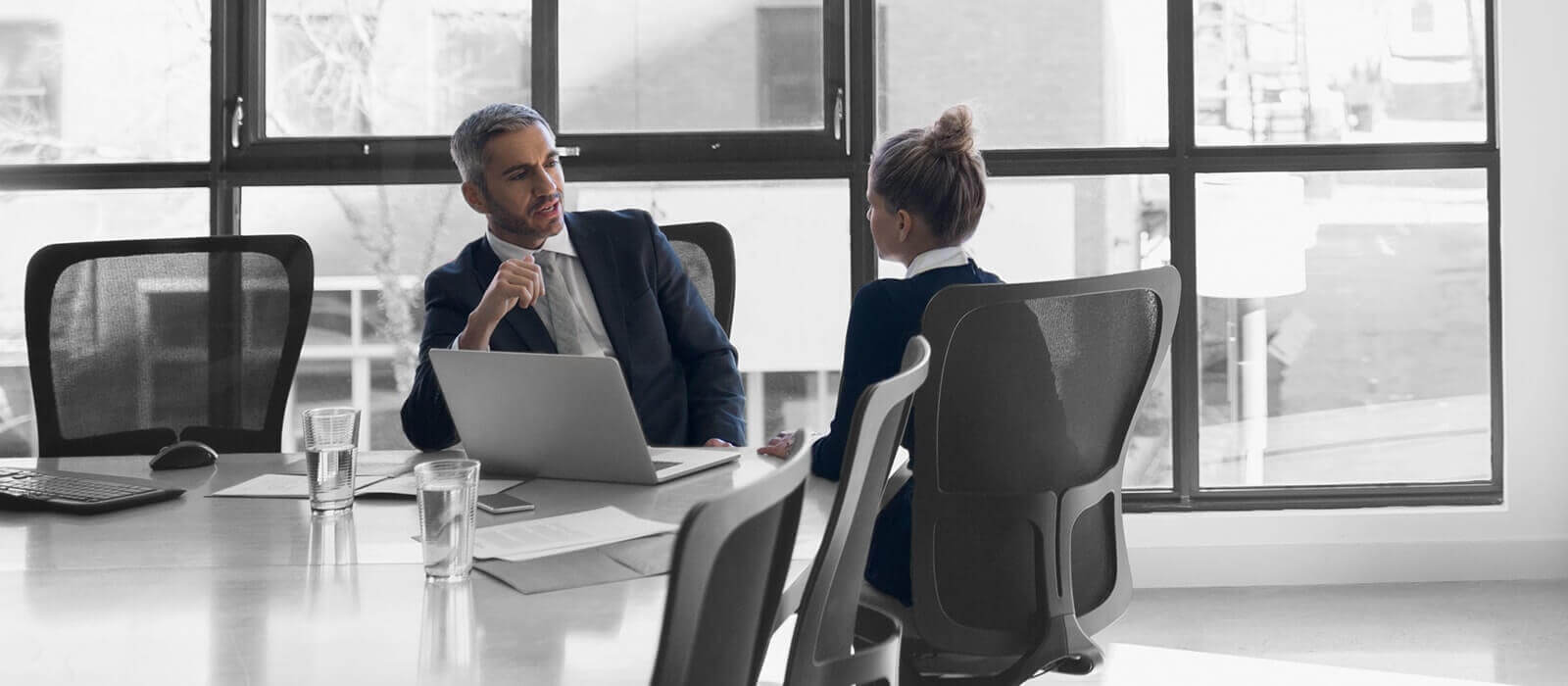 Picture of a man and a woman in an office having a discussion.