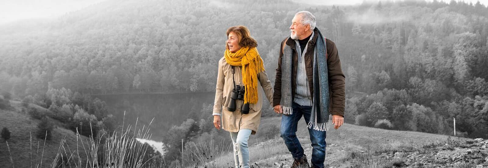 A happy older couple hiking in the mountains together